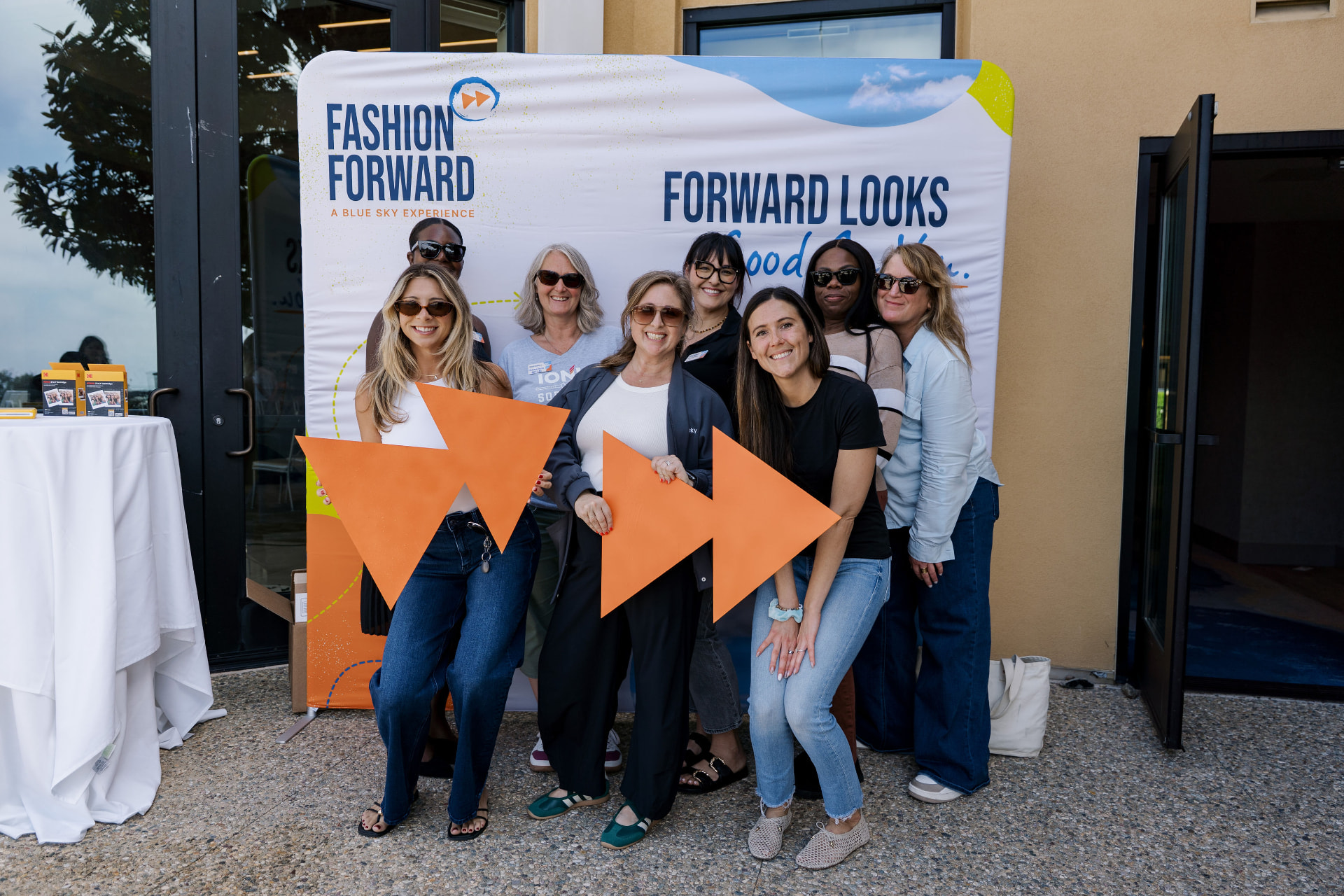 Guests posing with fast-forward props in front of the Fashion Forward backdrop